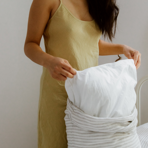 female taking pillow out of cover