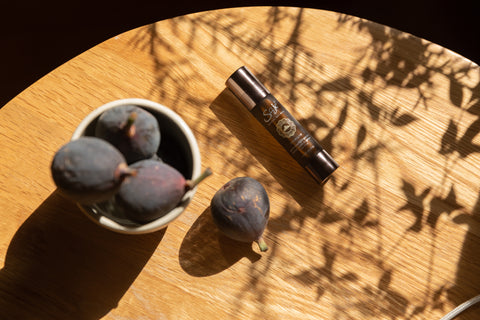 Immune roll-on on a wooden table next to a bowl of figs