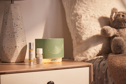 A collection of Saje products from the children's line sitting on a nightstand