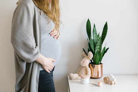 A pregnant mother to be holding her stomach