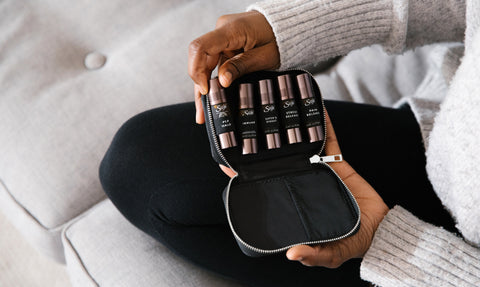 An opened pocket farmacy case containing five Saje essential oil roll-ons