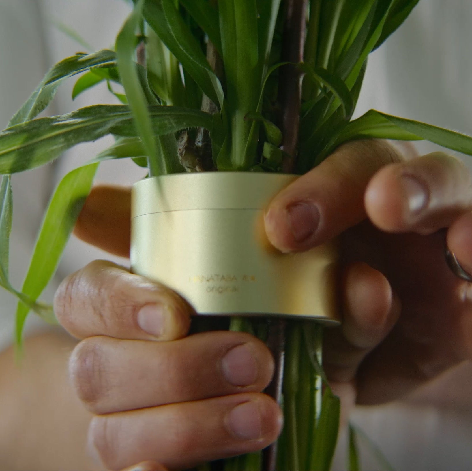 Close-up van handen die zorgvuldig stelen vastmaken met een Champagne Gold Hanataba twister.