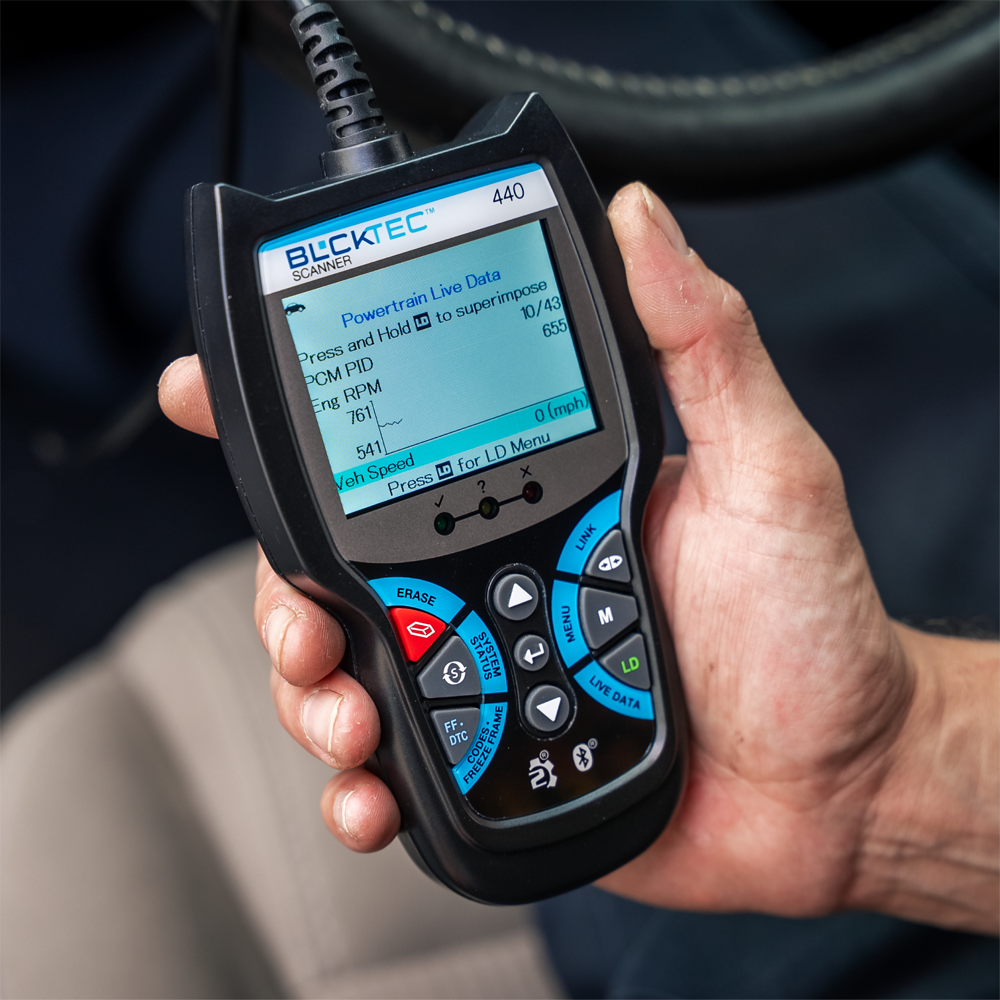 Man monitoring his car vitals on a BLCKTEC 440 Advanced Handheld OBD2 Scanner