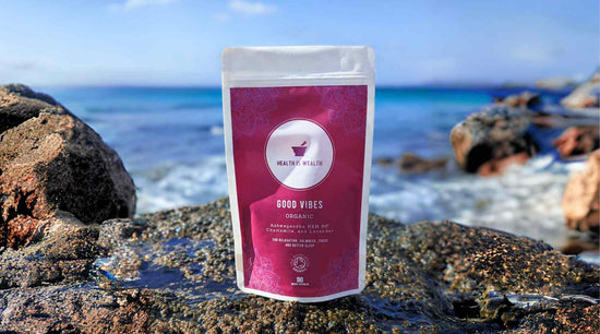 Good Vibes supplement pouch standing on rocks on a sunlit beach with crystal blue waters of the Atlantic Ocean in the background