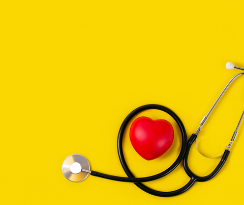 stethoscope on a yellow background with a red heart