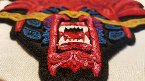 A foreshortened close up of the lower jaw textured stitching and mouth.