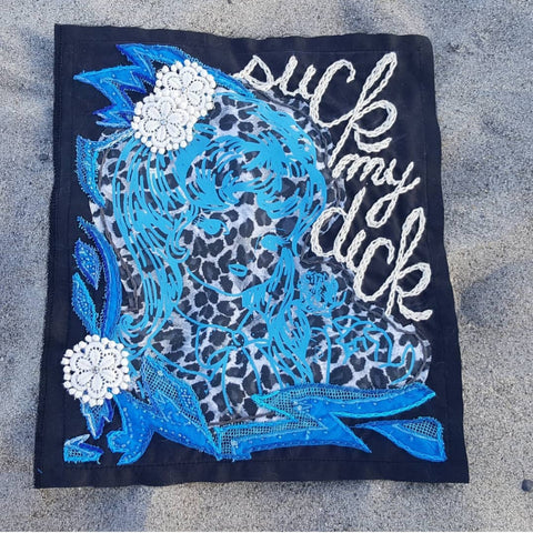 A mixed media back patch, containing an electric blue, line work screen print of a girl sniffing a rose. She's printed on a grey & black leopard print, and sewn onto a black rectangle background. A white chainstitch scrips starts in the top right corner and extends down the right side, reading "suck my dick". Bright blue beaded accent fabric and white flowers are appliqued from the top left corner down the left side of the patch, and extend across the bottom.