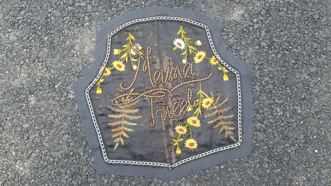 "Mama Tried" back patch on pavement. The patch is centered in the image, with a slight tilt towards the left.