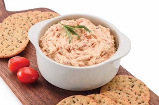 Dip in a white bowl with crackers on the side