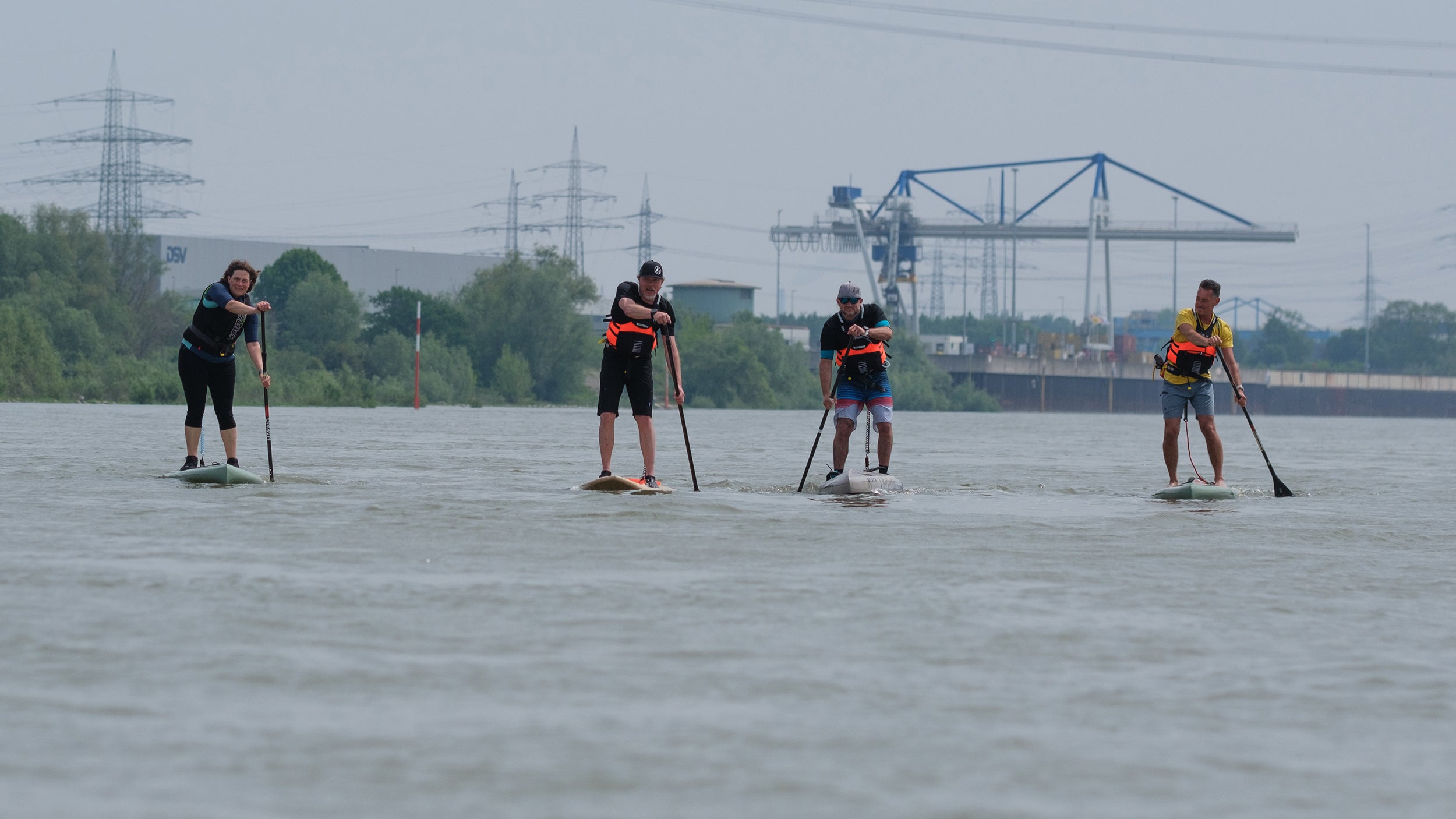 Die vier Freunde auf dem Rhein, im Hintergrund die Schornsteine der industriellen Umgebung