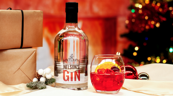 Nelson's Black Forest Gin with Negroni in front of Christmas themed background.