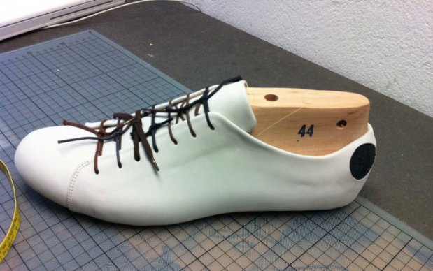 Cream Atheist shoe being stretched on a wooden last.