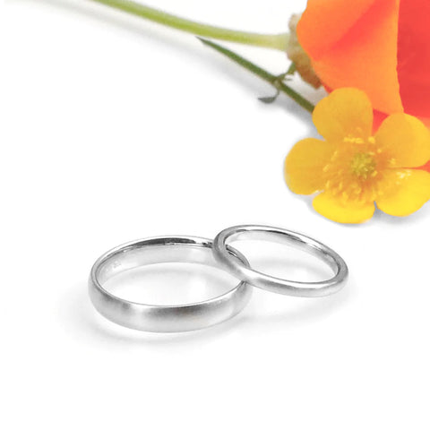 Two platinum domed wedding bands with flowers.