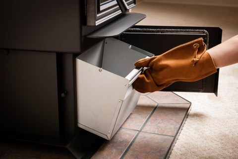 Close up of a gloved hand accessing a pellet stove