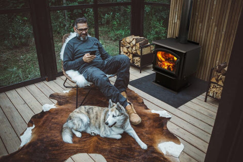 An image of a man and dog relaxing in front of a Quadra-Fire Millennium Wood Stove