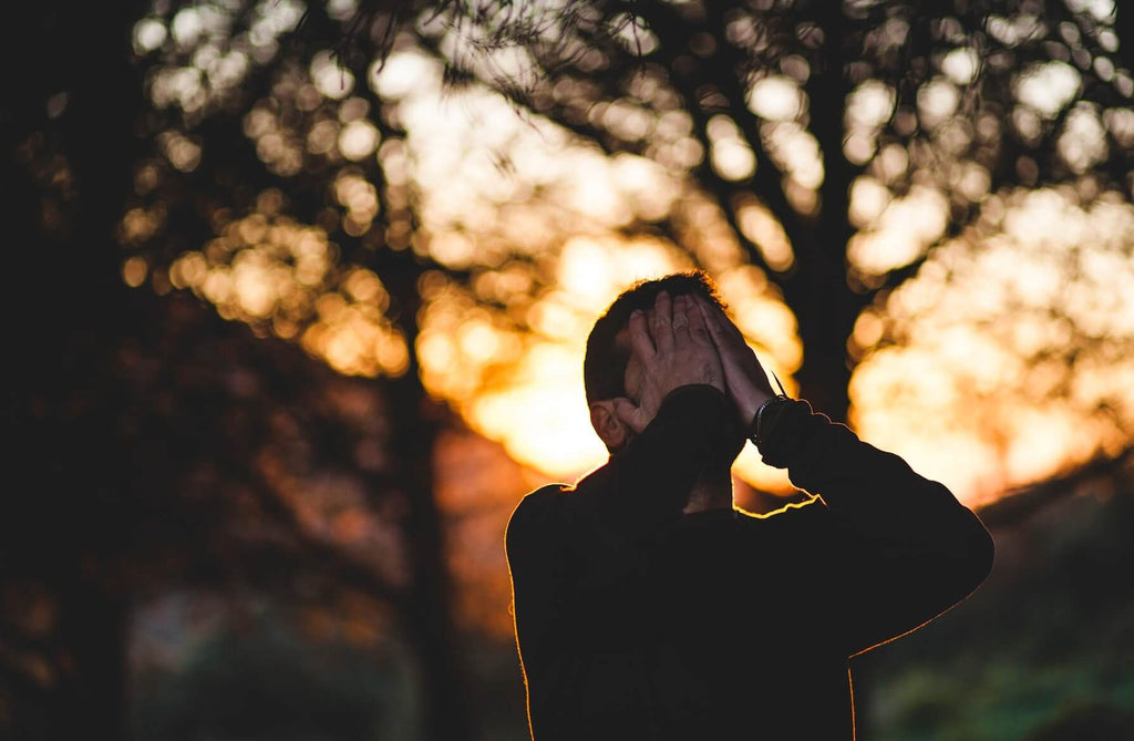 Man with his hands on his face demonstrating regret