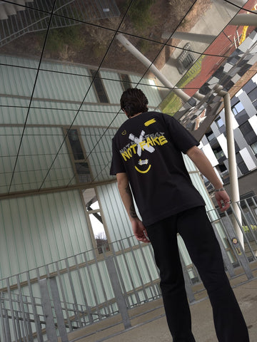 Black oversized graphic tee with a back motif under a modern building