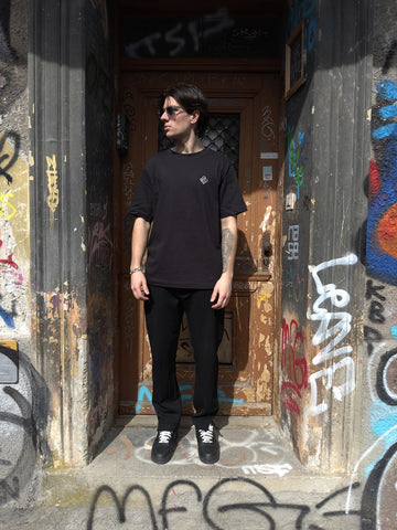 The basic oversize t-shirt in front of an abandoned building with graffiti
