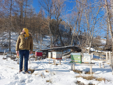 Morgan Bertin devant un rucher d'hivernage en montagne