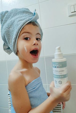 Jeune fille qui montre le gel-crème nettoyant