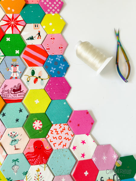 holiday hexagons ready to be sewn into a panel with thread and snips