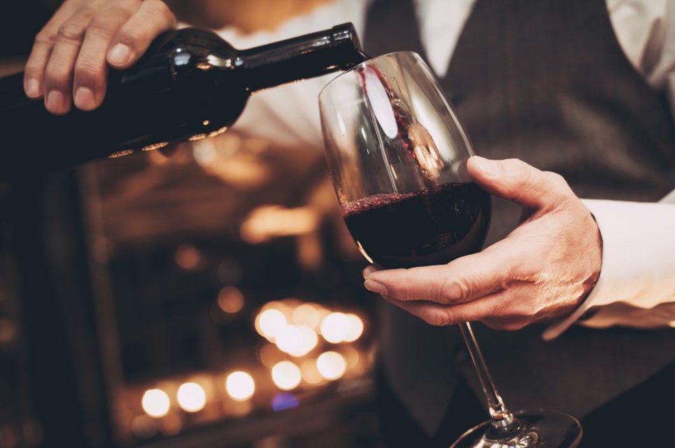 waiter pouring red wine in glass