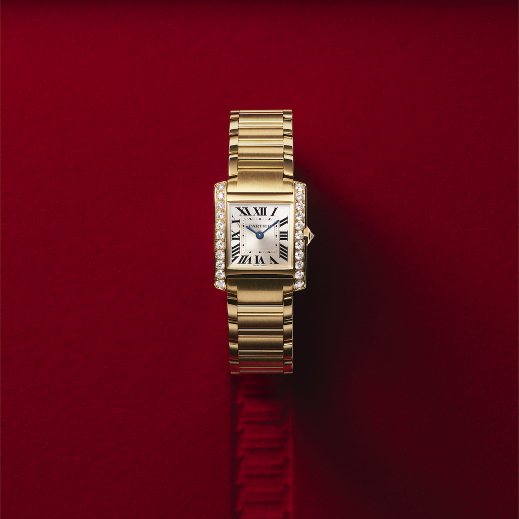 Montre Cartier Tank Française en or sur fond rouge