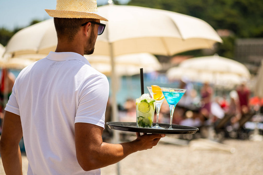 Beach waiter cocktails - How all inclusive resorts make money - GRANDGOLDMAN.COM