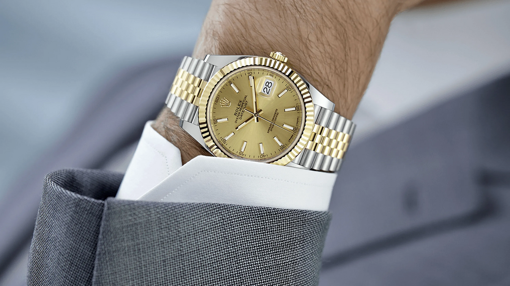 Grande Rolex Datejust 41 en or au poignet d'un homme en chemise blanche et suite grise, gros plan - - Les meilleures montres Rolex dans lesquelles investir pour 2023 - PARADIS FISCAL - TAXHVN.COM