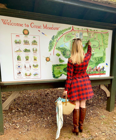 Lydia marie elizabeth stands at the Great Meadow Property in the plains Virginia pointing to the map she painted for visitors to navigate the property