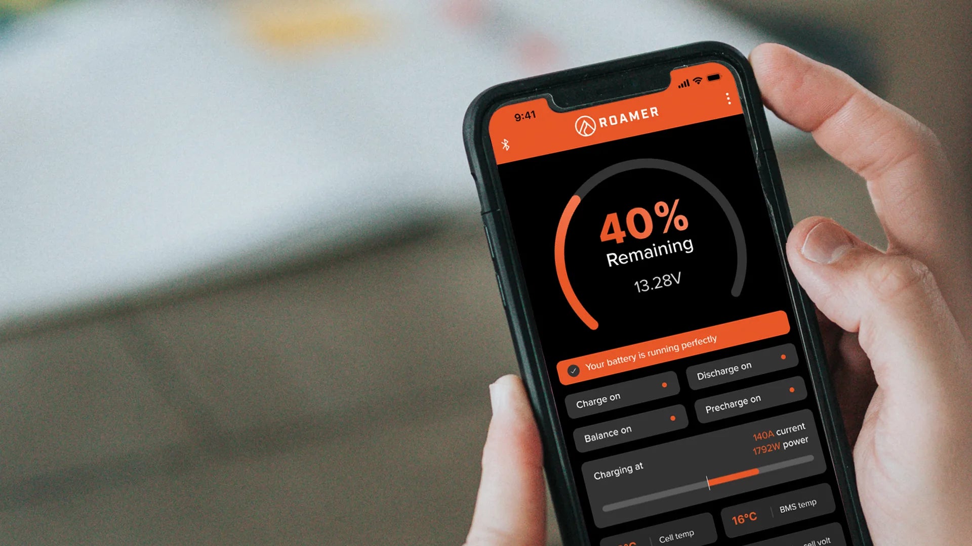 Roamer's SMART BMS app in a man's hand.