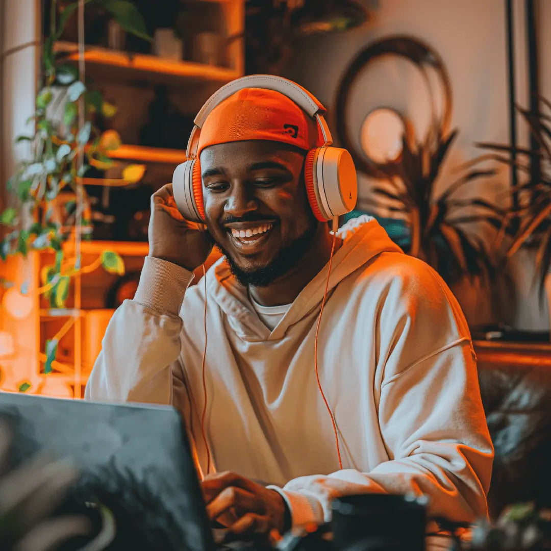 A man on his laptop smiling as he makes music with sample packs from The Sample Stop