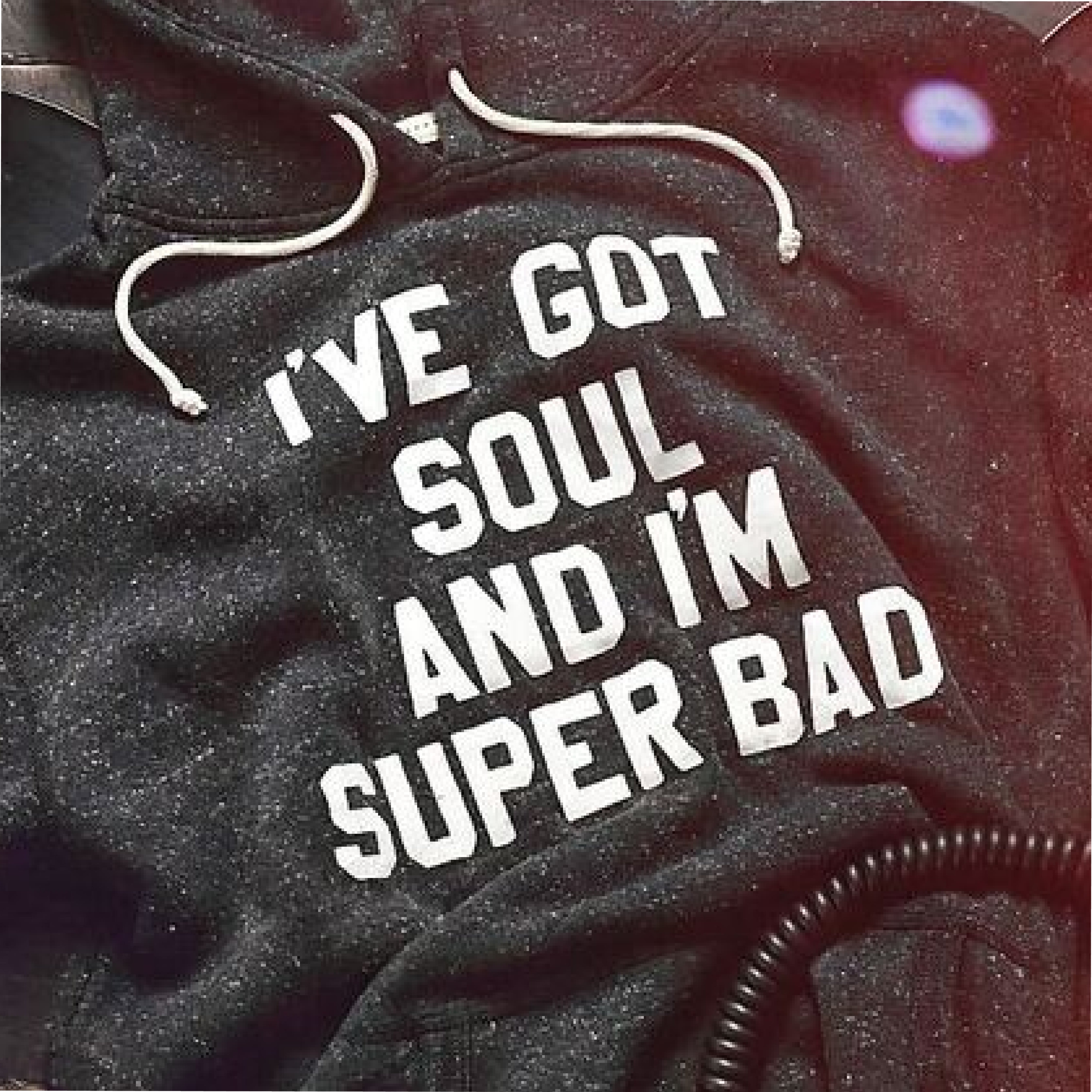 A close-up of a dark sweatshirt with the text 'I've got soul and I'm super bad.'