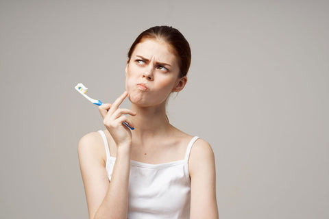 Woman thinking about brushing her teeth