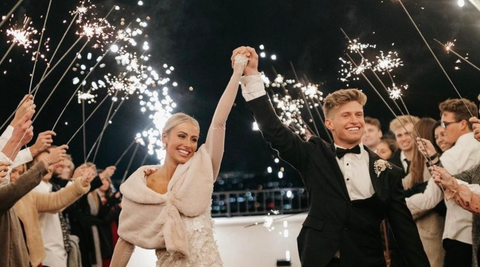 husband and wife exiting wedding venue with a wedding sparkler sendoff