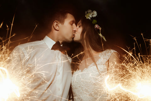 Couple in wedding dress and tuxedo holding a wedding sparkler