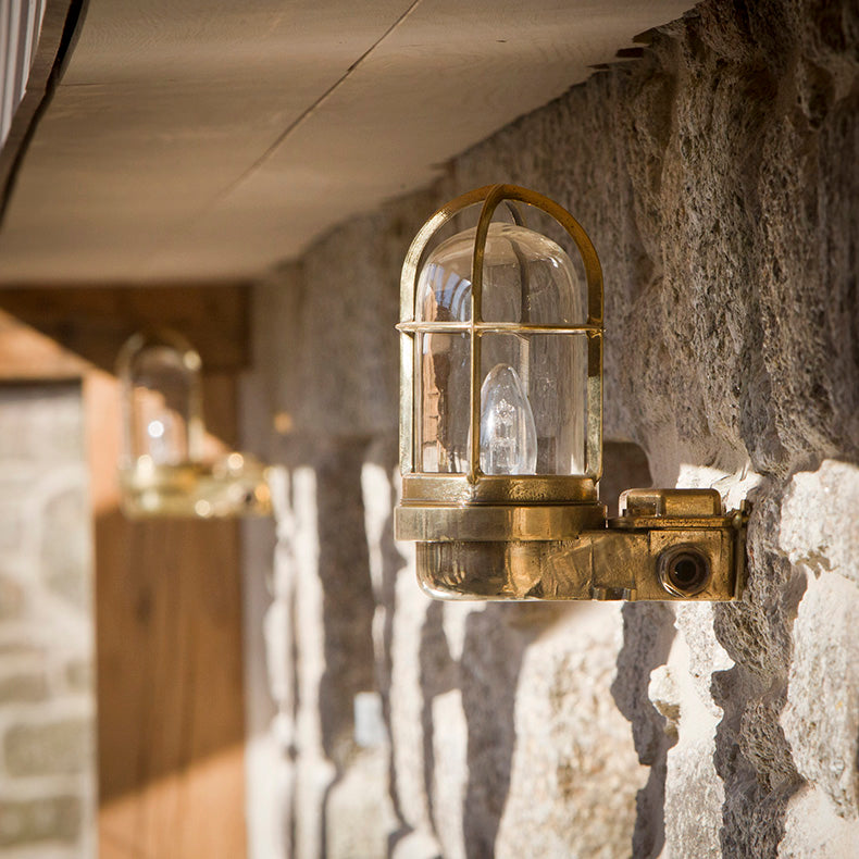 Brass nautical bulkhead light in hallway