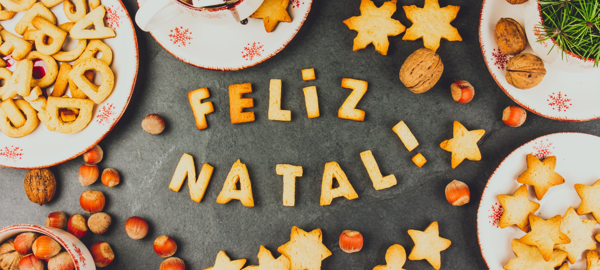 Foto mit Weihnachtsplätzchen und Nüssen und dem Schriftzug Feliz Natal.