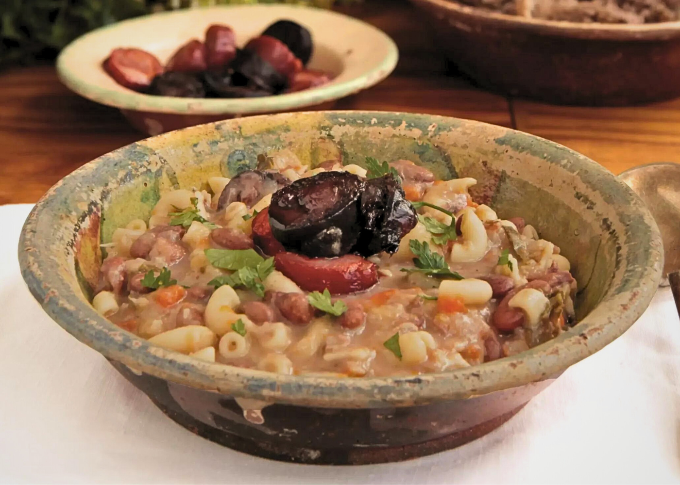 Foto eines köstlichen Tellers mit "Sopa Caramela", einem traditionellen portugiesischen Gericht. Cremige Suppe aus Gemüse und zarten Bohnen, schön garniert mit Kräutern und Paprika. Erinnert an gemütliche Familienessen und kulinarische Abenteuer.