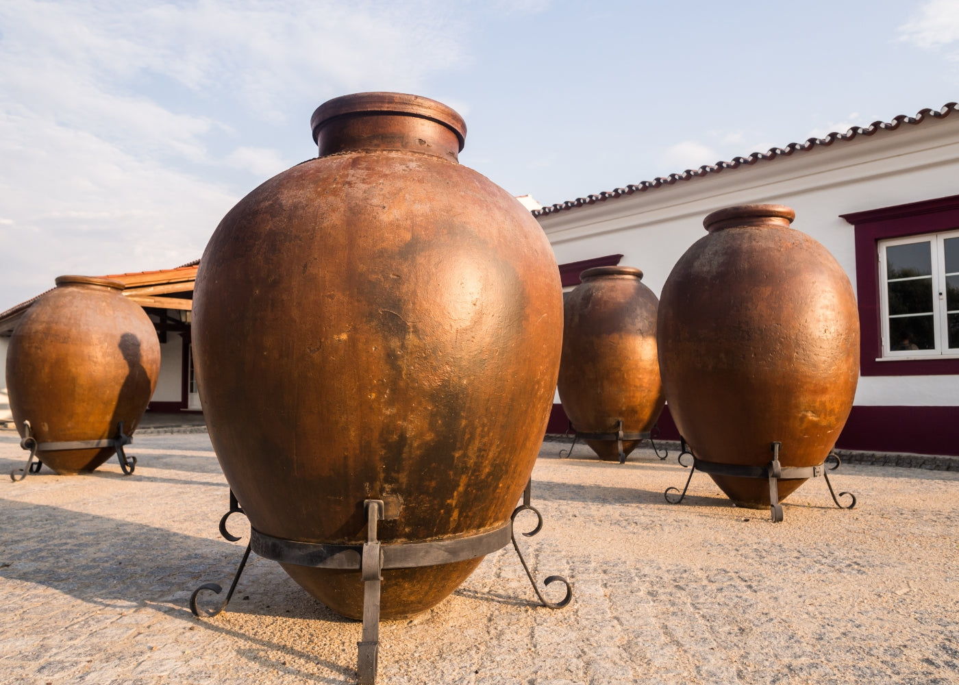 Bild von traditionellen Ton-Gefäßen für Wein vor einem malerischen Weingut in Portugal.