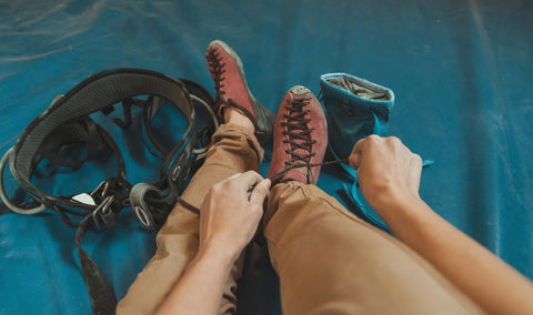 Climber lacing up shoes for a session in the gym