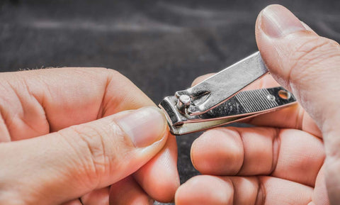 Climber using finger nail clippers to trim finger nails