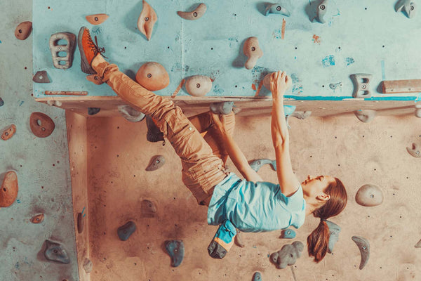 Female climber throwing a heel hook high off the ground