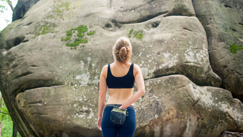 Woman climber looking at a boulder outdoors to figure out her beta