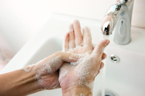 Climber washing hands using soap and cold water after a session