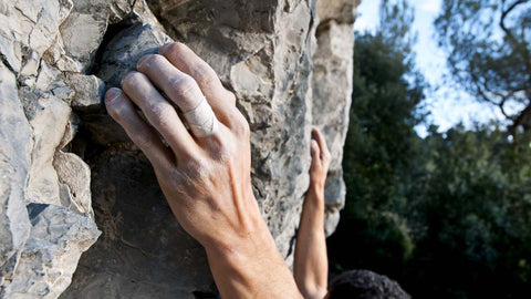 Climber grabbing on to natural rock outdoors