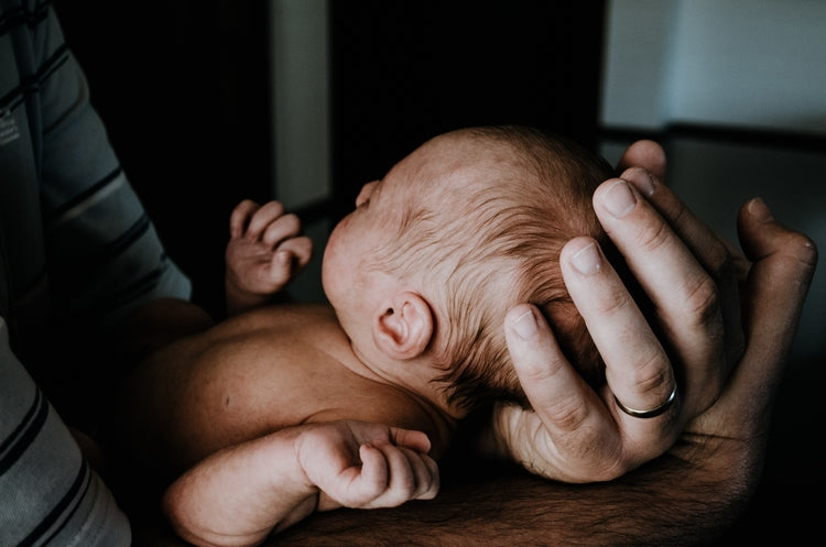 Mann hält baby in armen