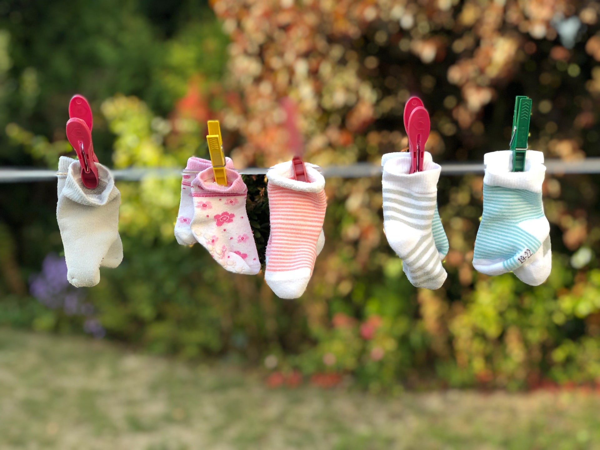 Baby socks hanging on a washing line outside