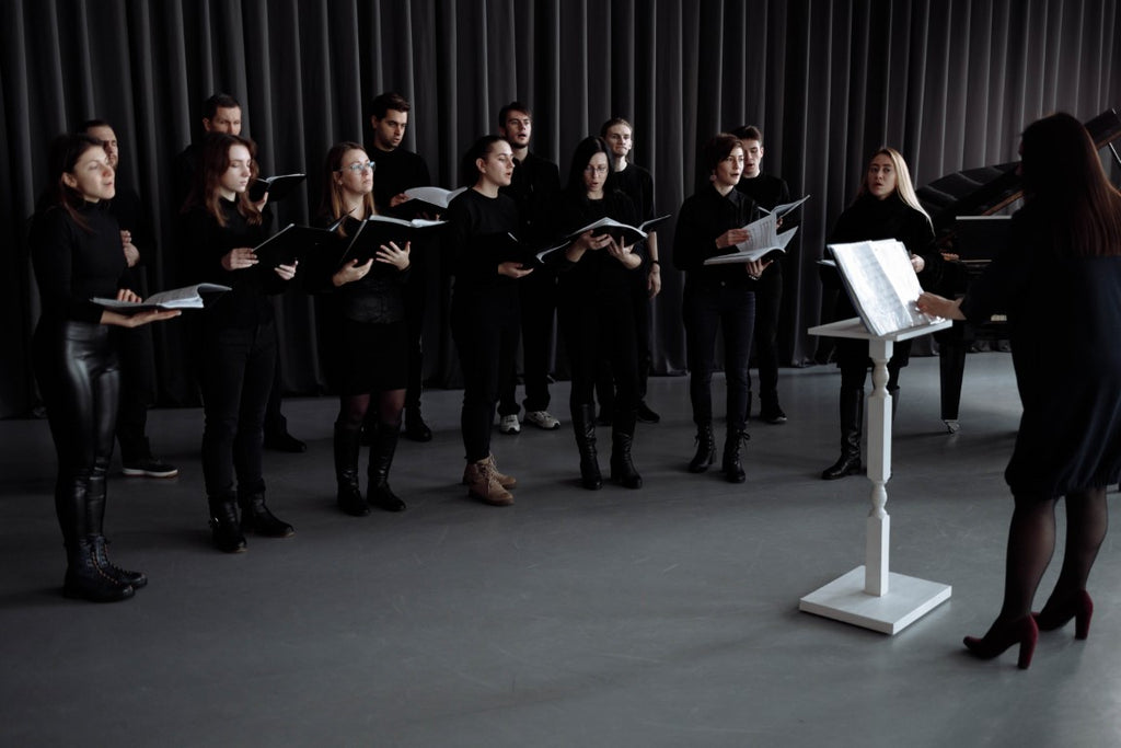 A choir wearing black clothes singing together. Photo via Pexels.com