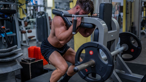 Man doing quadriceps exercise on hack squat machine at gym